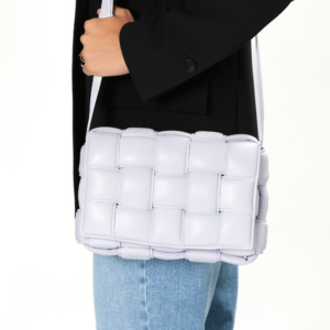 Frau trägt eine helllila Handtasche im Flechtmuster der Marke Bottega Veneta.