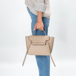 Frau trägt ein beige Lederhandtasche der Marke Celine.