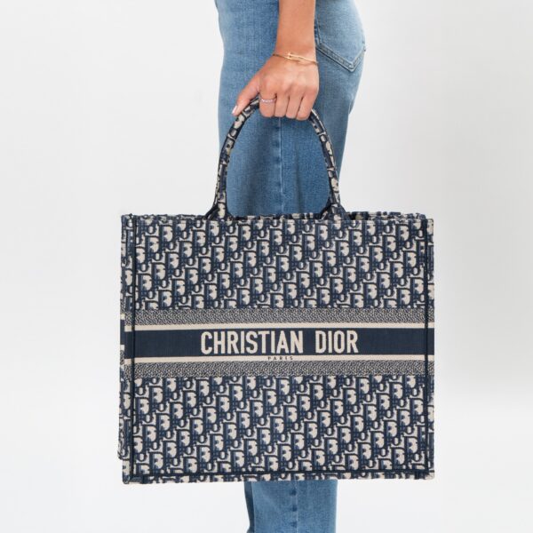 Frau trägt Tote Bag in Blau und Beige aus Jacquard-Gewebe der Marke Dior.